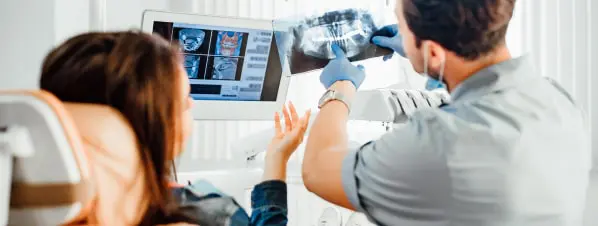 Dentist Showing An X-ray To A Patient