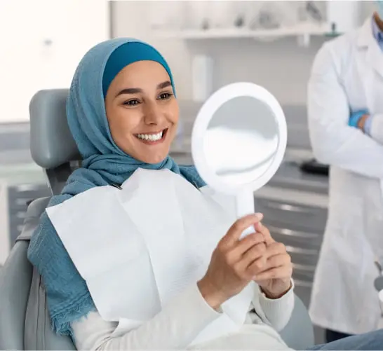 Woman In A Blue Hijab Looking At A Mirror