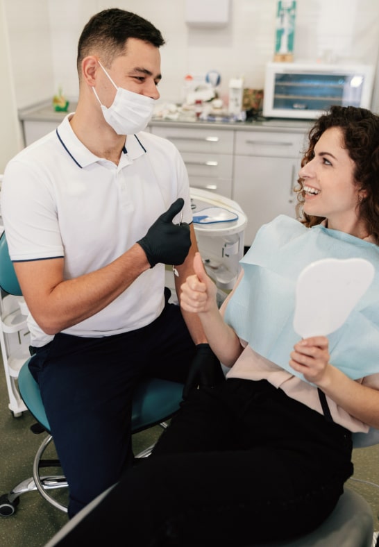 A Smiling Patient And Dentist Giving Thumbs Up
