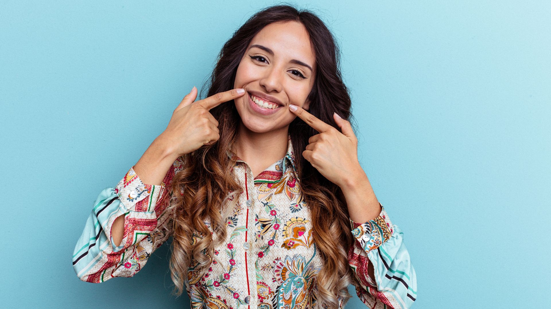 Woman Smiling and Pointing at Her Teeth